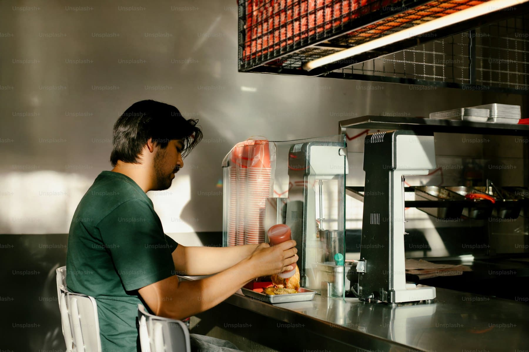 A cook plating a burger in a restaurant kitchen